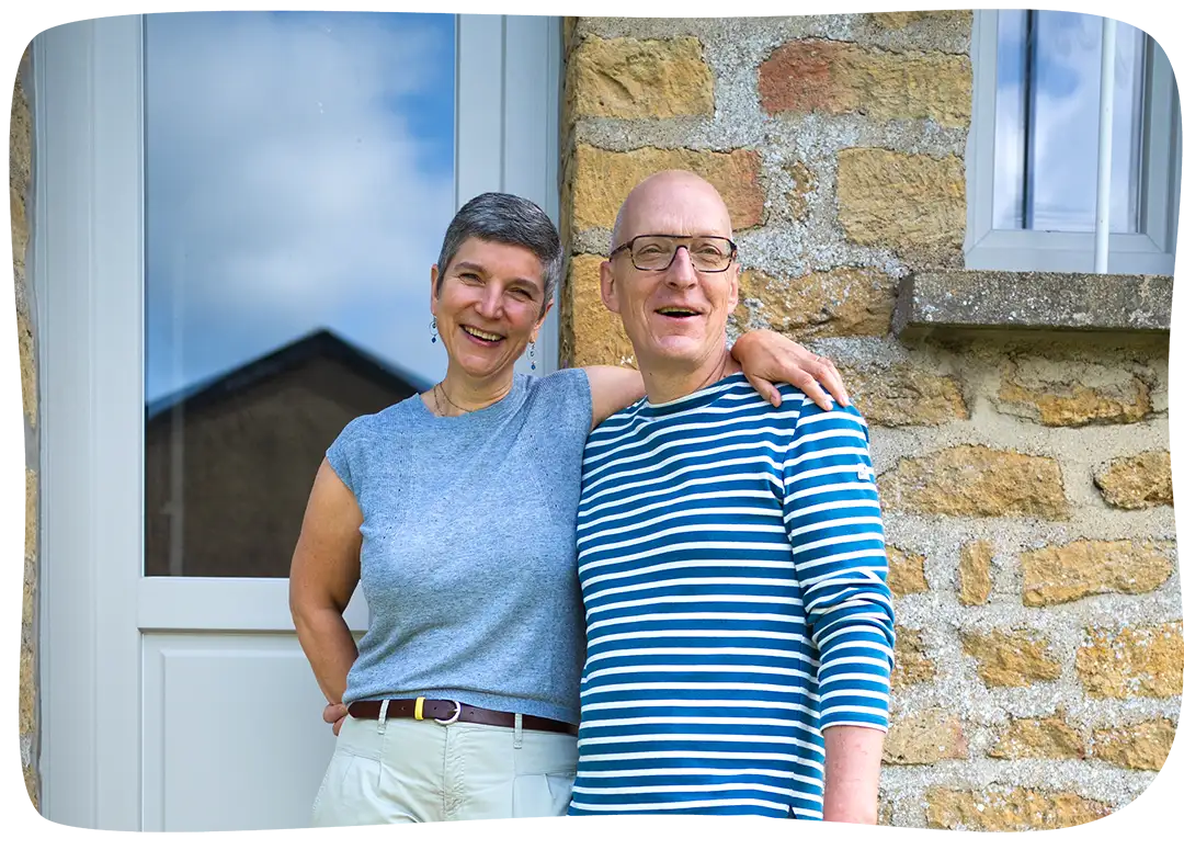 Chantal et Bernard devant la maison souriant